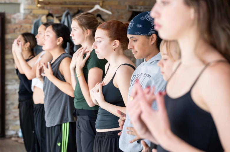 A group of dancers standing during a training session in a dance studio