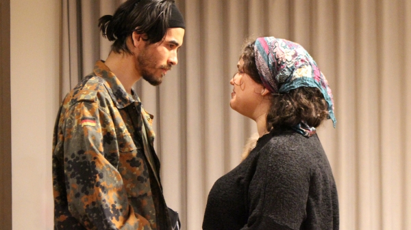 Two actors looking at one another during a drama presentation 