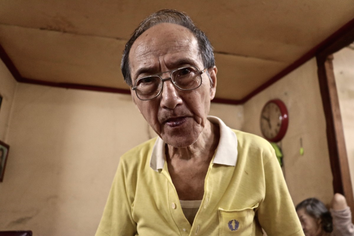 Older Chinese-Cuban man looking into the camera.