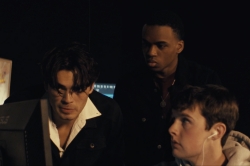 Three people looking at a computer.