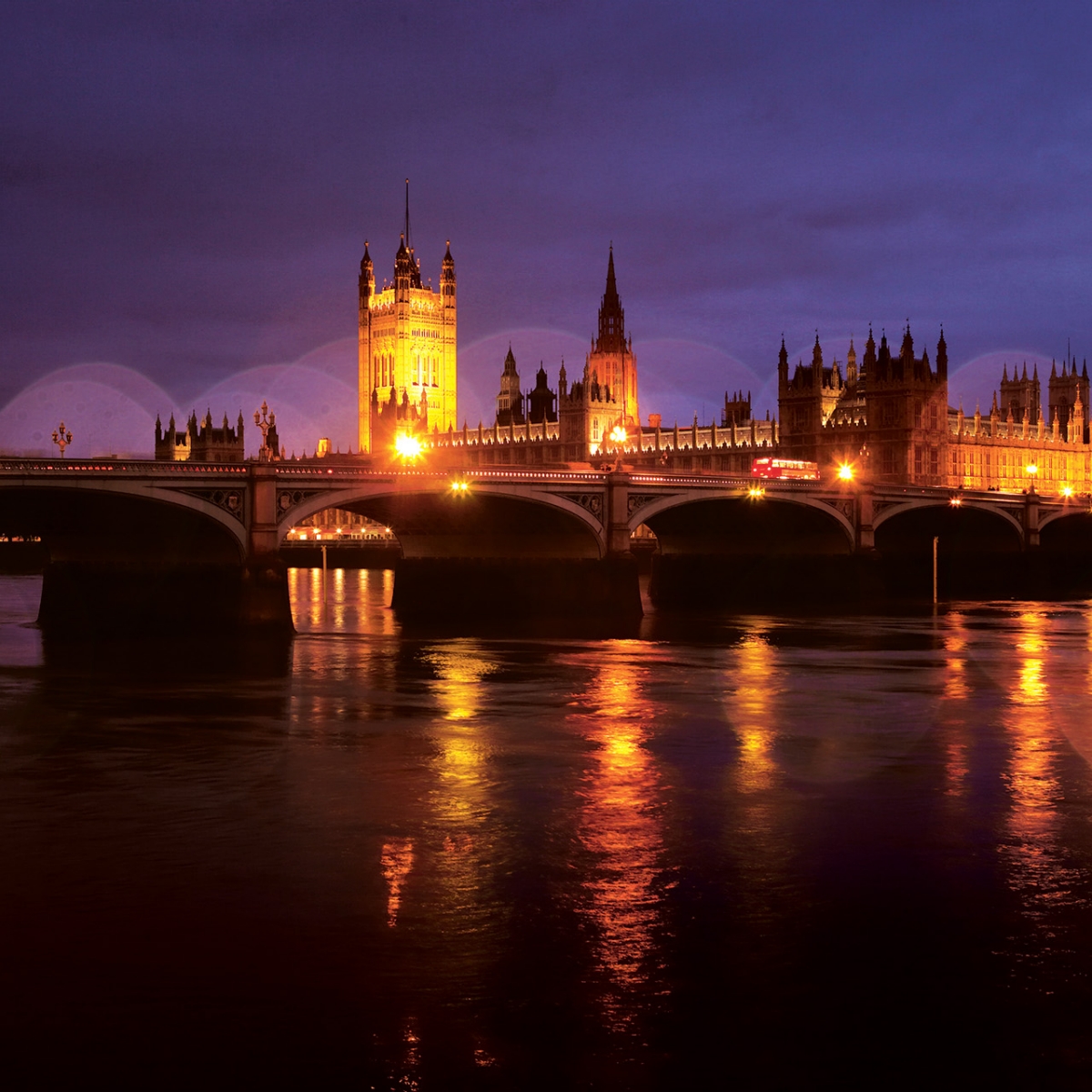 Nighttime image of the Thames River, the castle, and Big Ben in London.