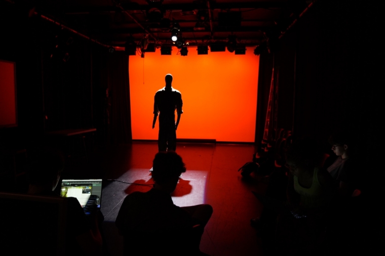 Students working on lighting alongside instructor
