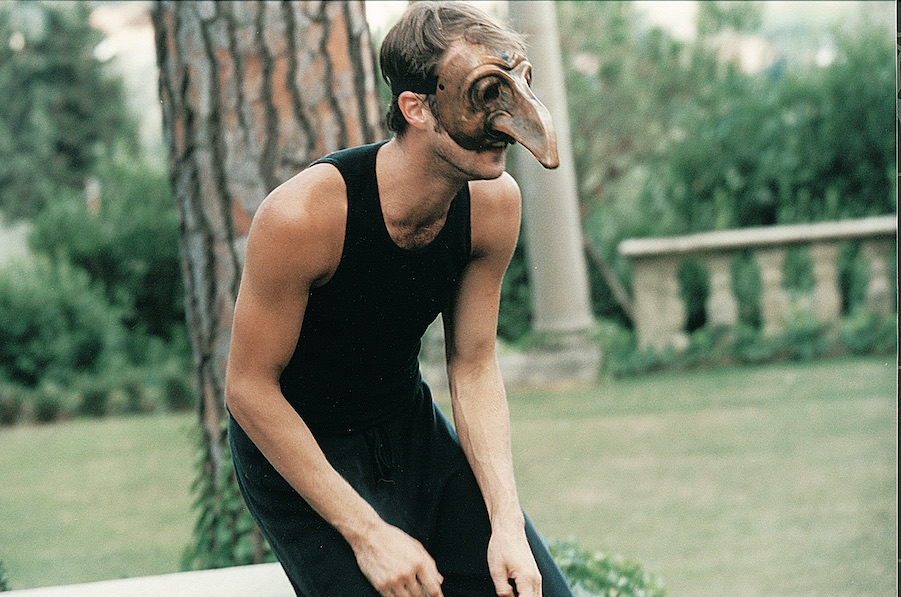 Male actor wearing a mask with long nose, outside in Florence, Italy.