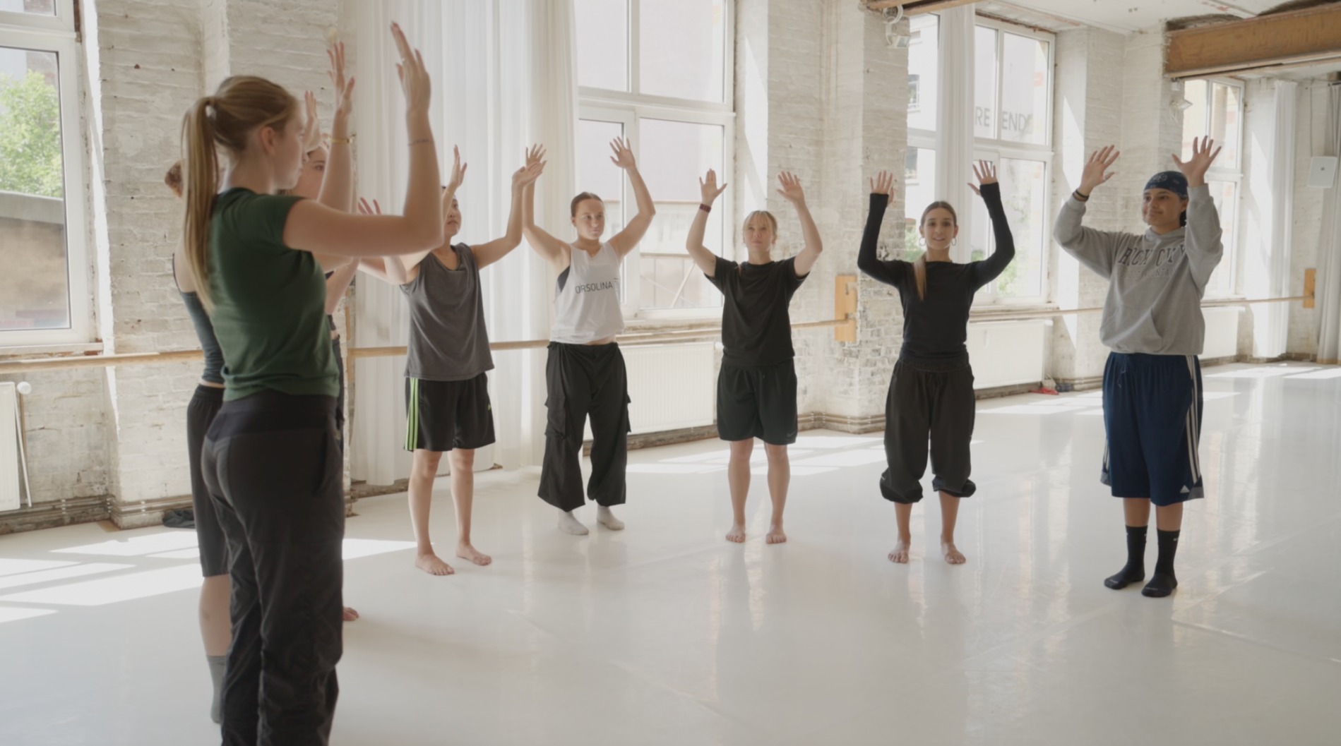 Still image of dancers training in a studio