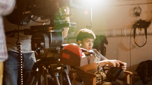 Students using a 35mm film camera on set