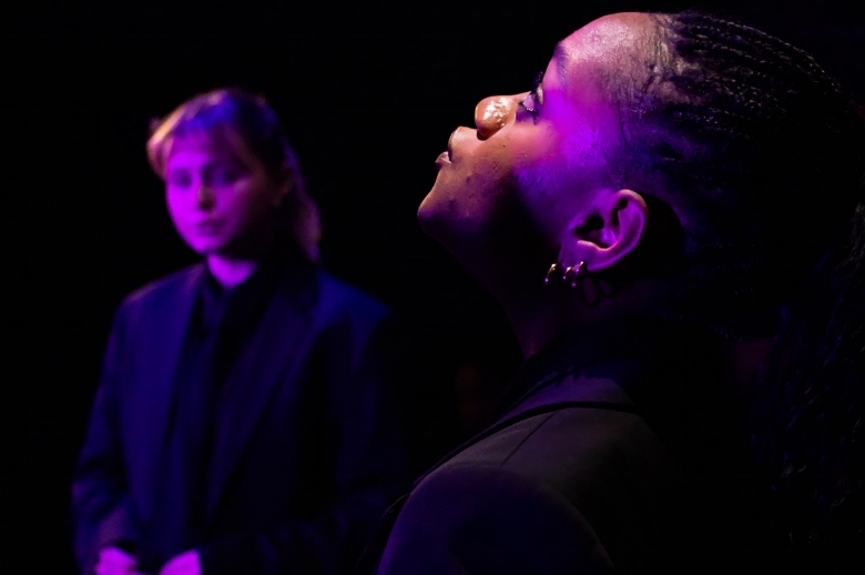Actress faces toward the sky while other actress glances at her from a distance during a scene from the Spring 2026 final presentation of "Measure for Measure".