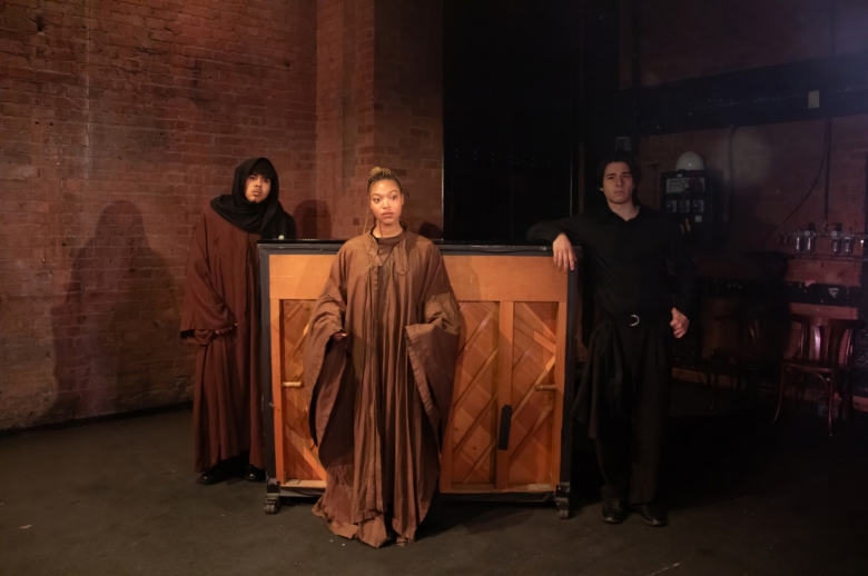 Actors standing near a piano during a scene from the Spring 2026 final presentation of "Measure for Measure".