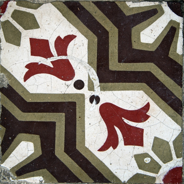 Fleur de lis red, white, green, and black painted ceramic tile.