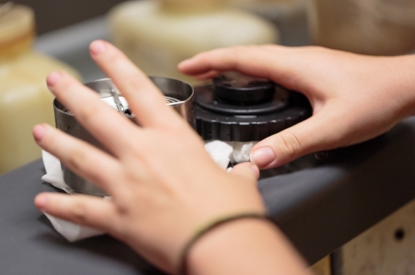 Close-up on a student's hands adjusting a camera lens