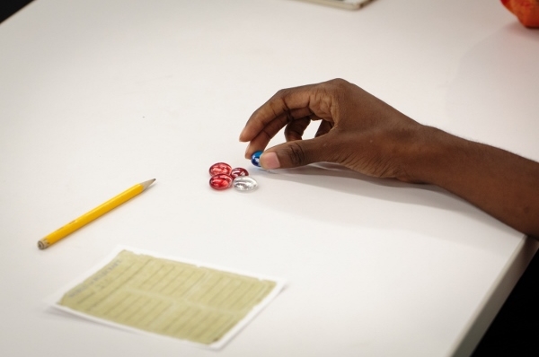 Student's hand picking up a game piece