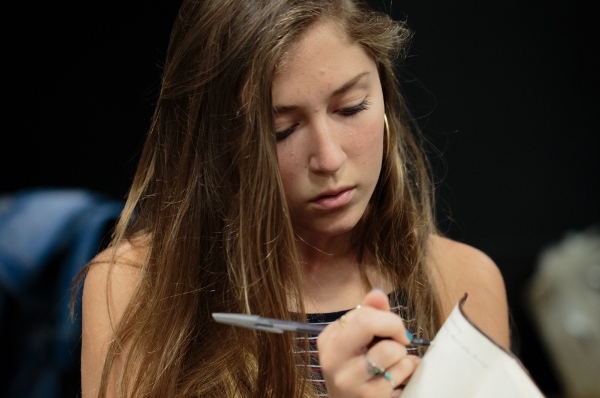 Student making notes on a script in a classroom 
