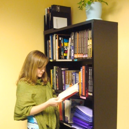 Person reading by bookcase