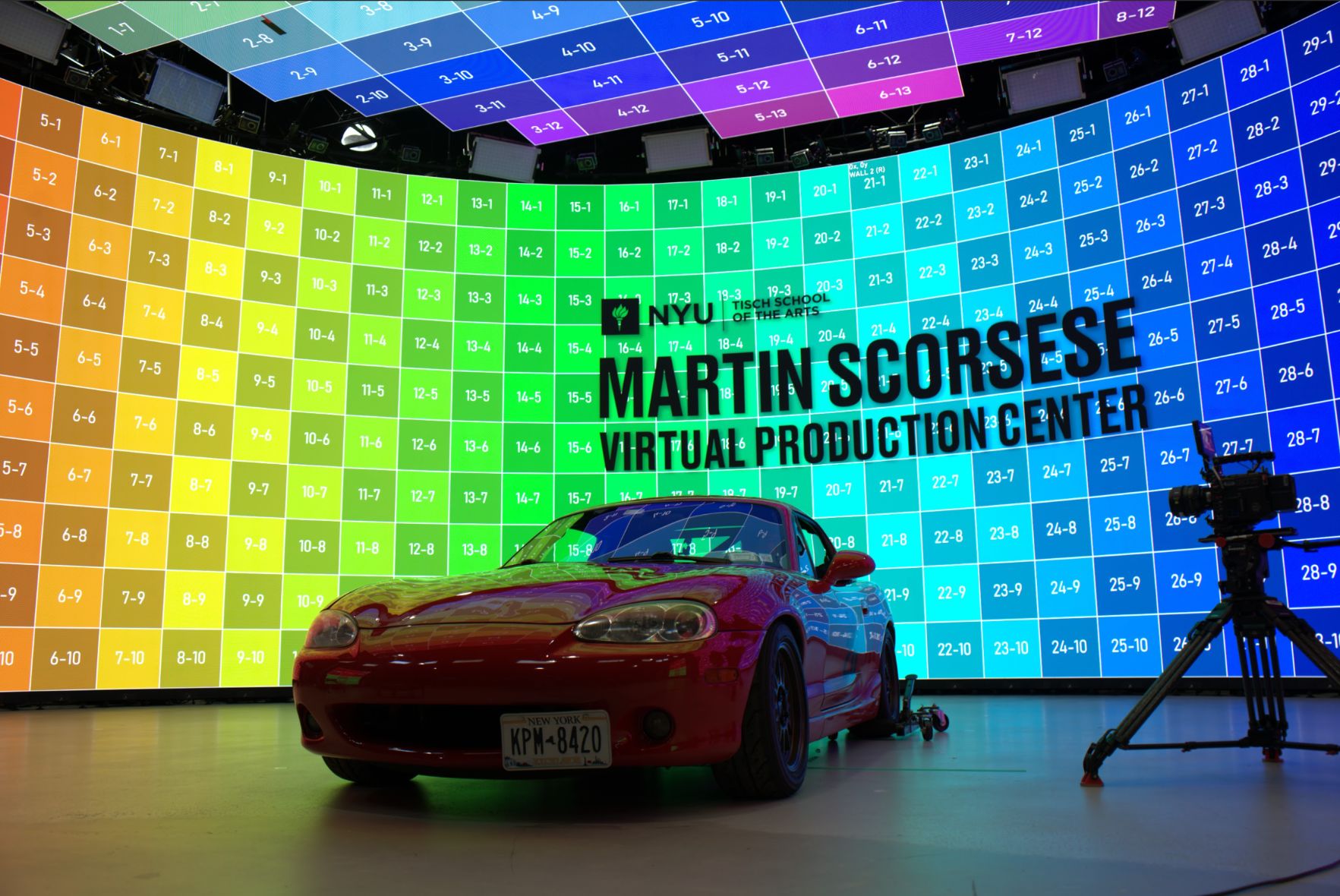 a red sports car in front of an LED volume wall