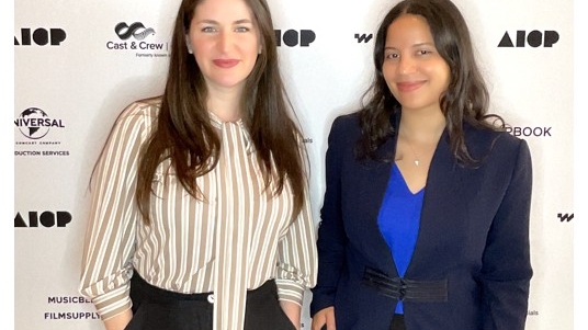 Kasey O’Brien and Ariana Taveras in front of a step and repeat at AICP