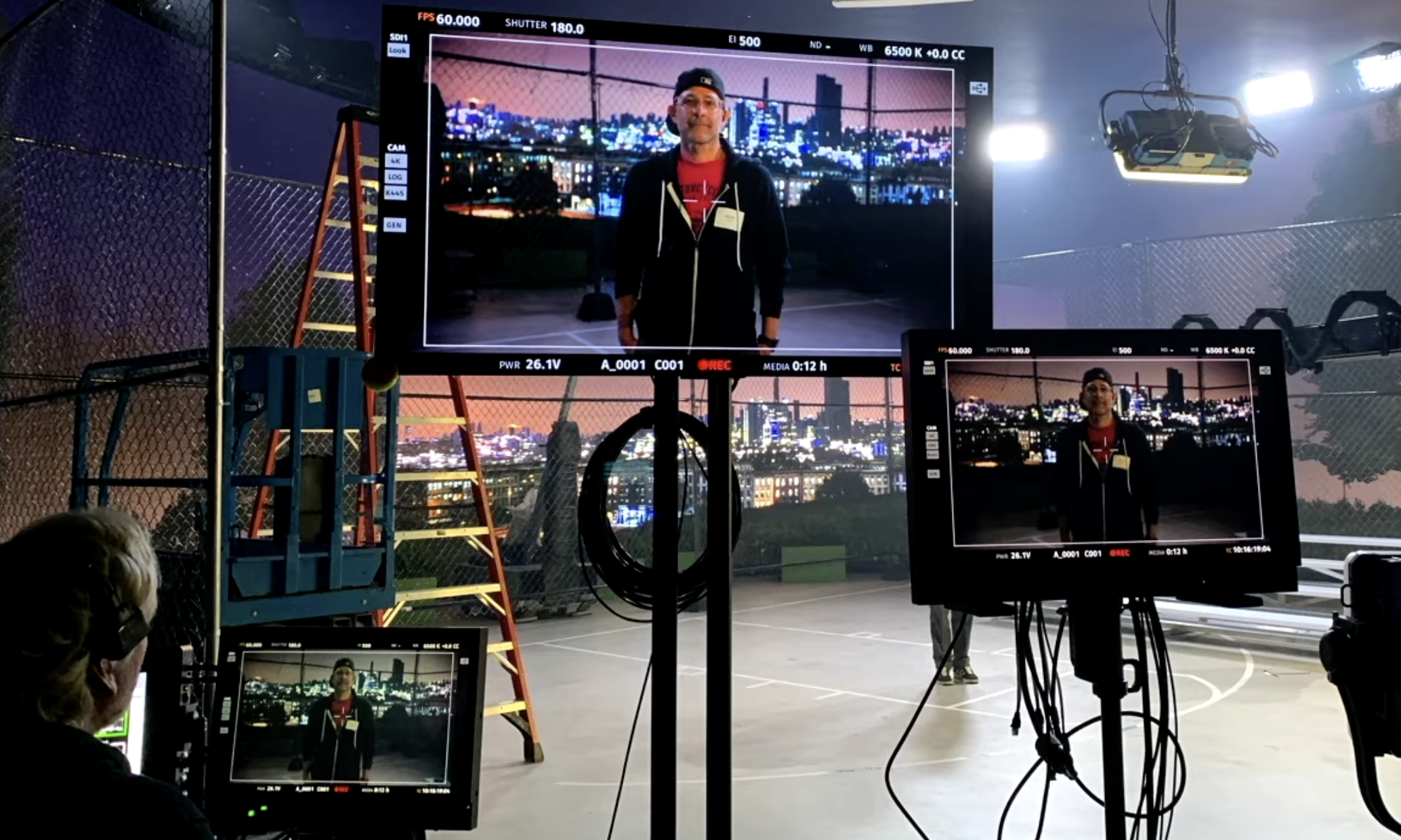 Behind the scenes photo of the Virtual Production stage with monitors and a subject on screen.